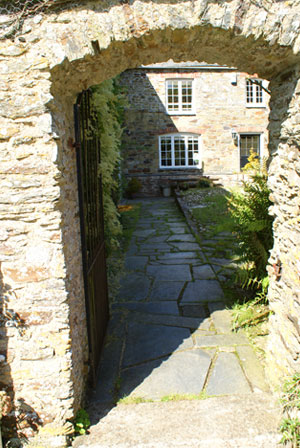 A view into the stone courtyard of a cornish cottage after landscape design